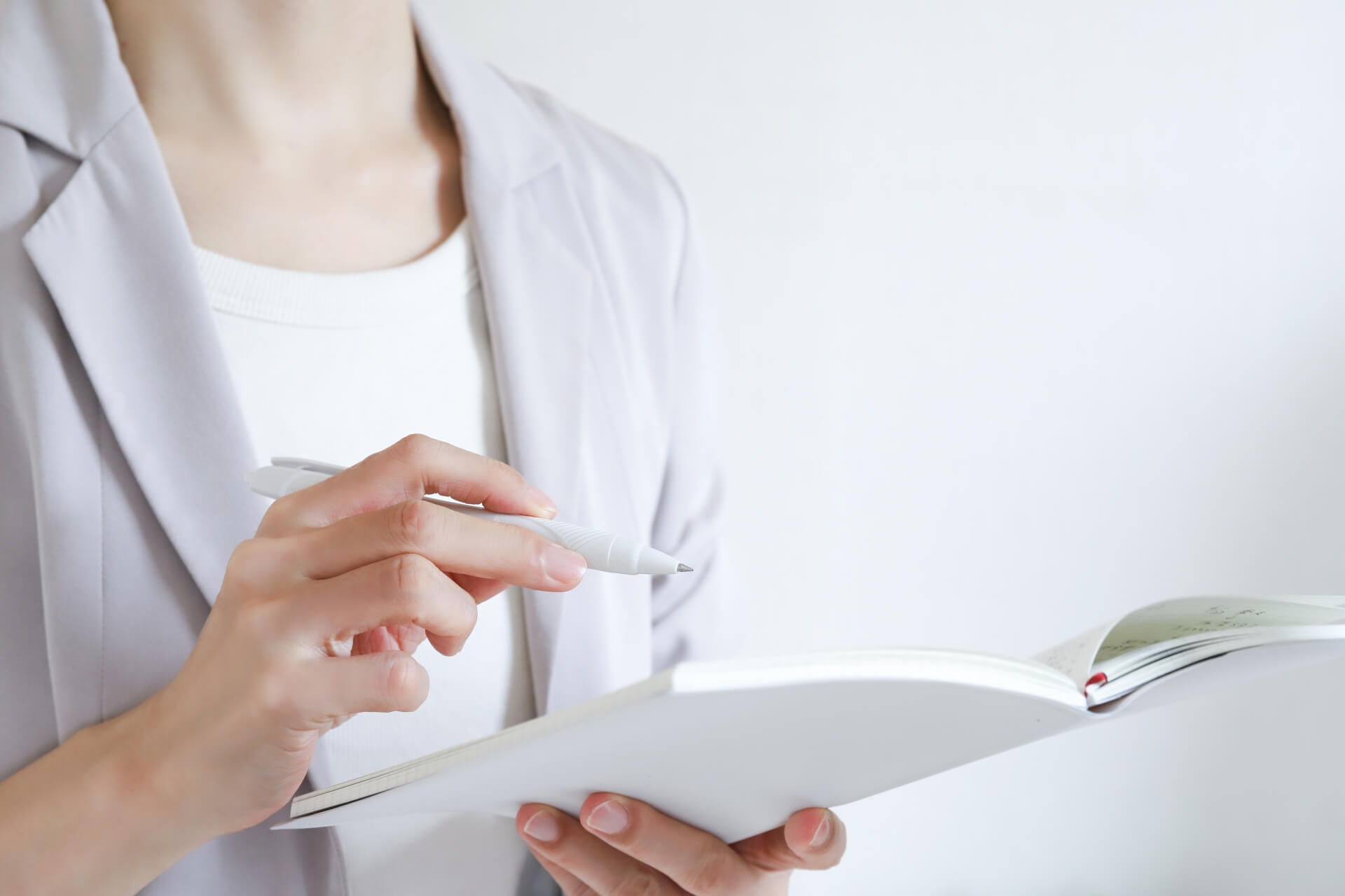 ノートにメモを取るビジネスパーソン