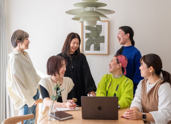 会議室で楽しく話すカラフルな服の人々