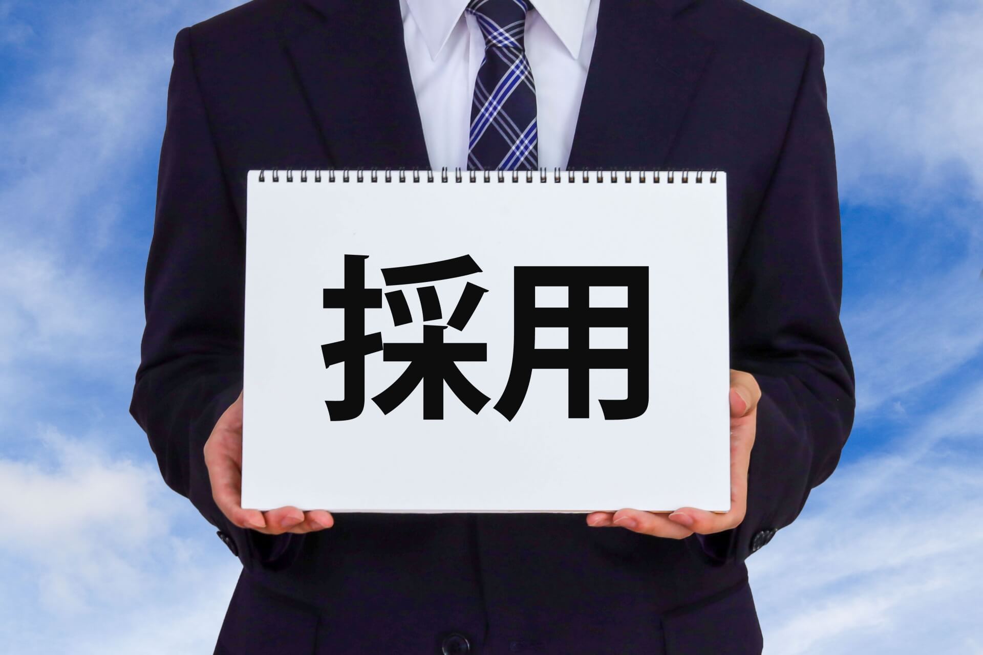 青空の下採用看板を持つ人物