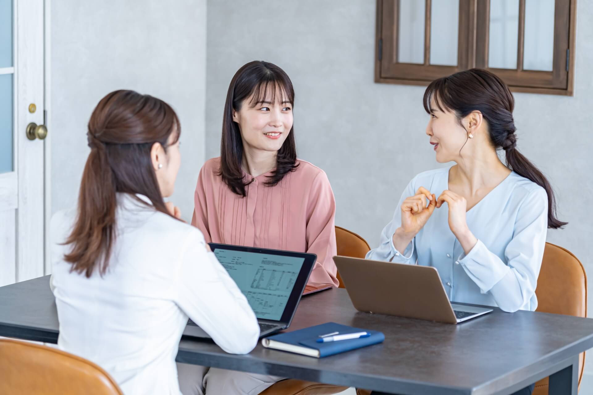 オフィスで和やかに会話する3人の女性